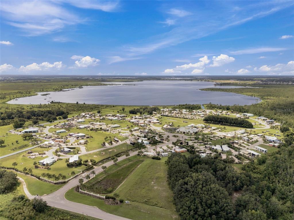 An aerial view shows a residential community situated next to a large lake — 3210 GREAT HERON LOOP, POLK CITY, FL