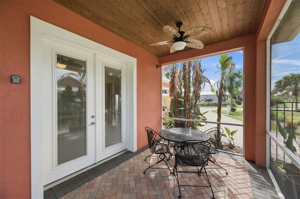 A screened-in patio features a brick floor, a ceiling fan, and a small dining set — 3210 GREAT HERON LOOP, POLK CITY, FL