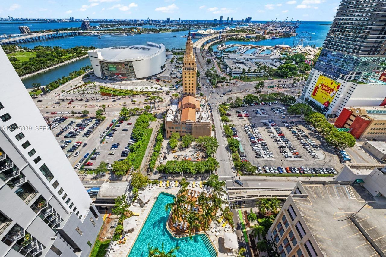An aerial view shows a swimming pool, parking lots, the Freedom Tower, and Miami waterfront — MIAMI, FL