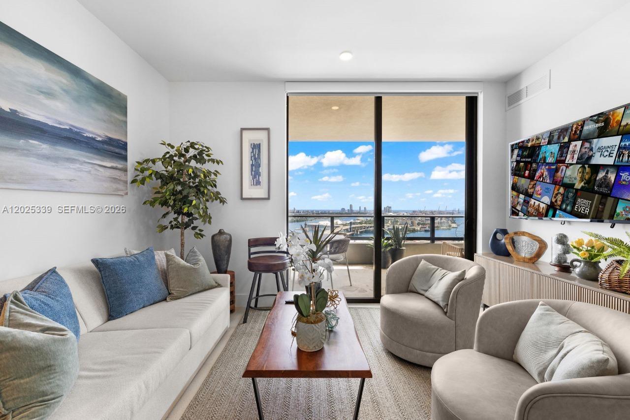 A living room features a sofa, two armchairs, a coffee table, and a balcony view — MIAMI, FL