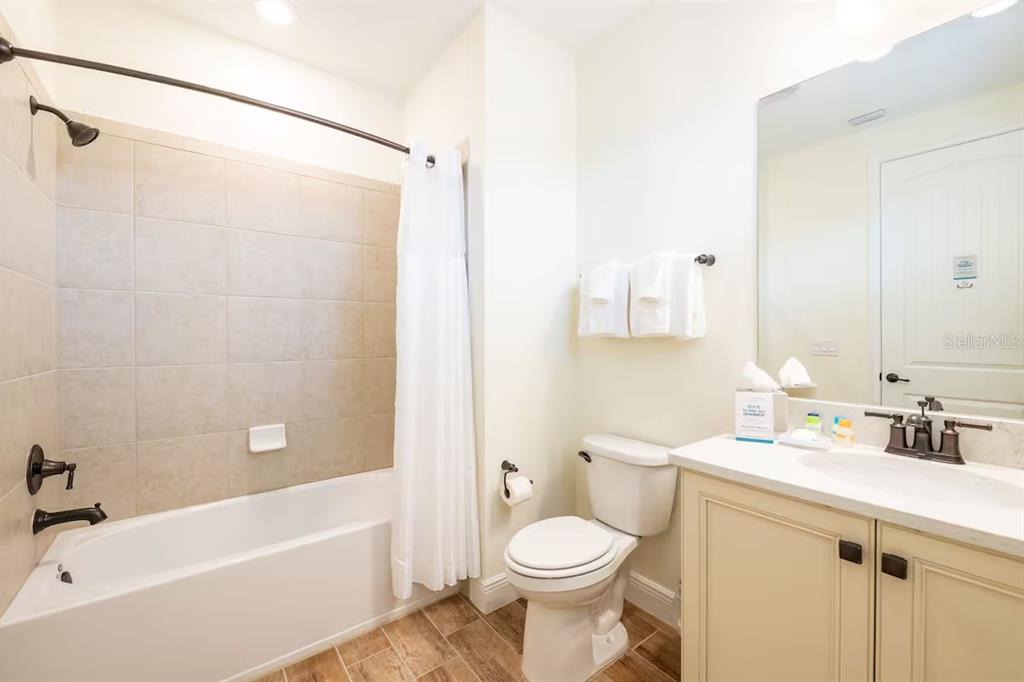 A bathroom featuring a tiled shower-tub combination, a white toilet, and a vanity with mirror — 2998 SALTED RIM ROAD, KISSIMMEE, FL