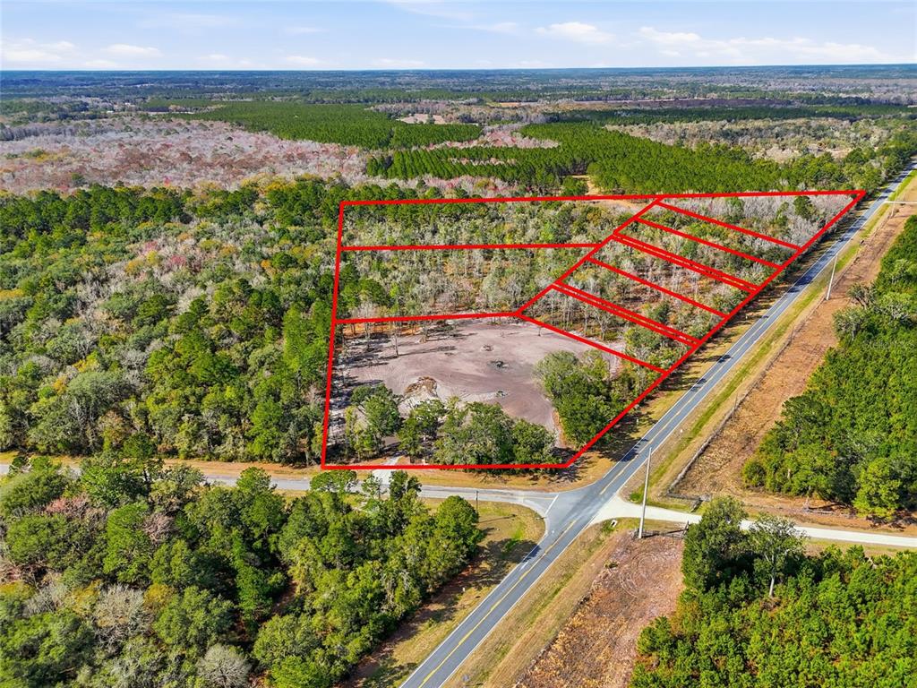 An aerial view shows a cleared plot of land outlined in red beside a road — 20994 SW COUNTY ROAD 18 Lot 2, BROOKER, FL