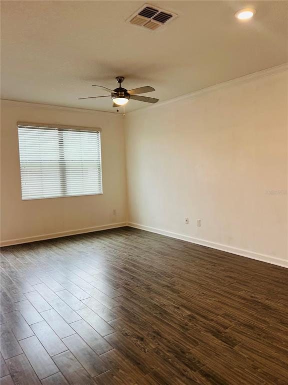 An empty room features wood-look tile flooring, a ceiling fan, and a window with blinds — 11258 WHISTLING PINE WAY, ORLANDO, FL