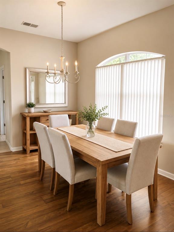 A dining room features a wooden table, six upholstered chairs, a sideboard, and a chandelier — 3578 VALLEYVIEW DRIVE, KISSIMMEE, FL