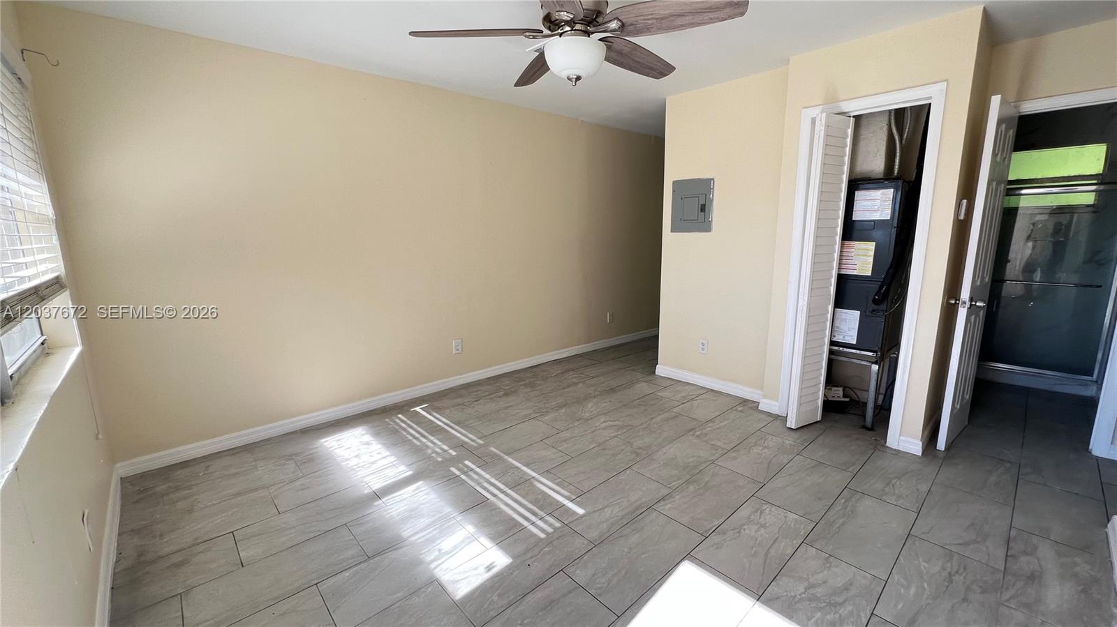 An empty room features light-colored tile flooring, beige walls, a ceiling fan, and a closet — 706 SW 4th Ter # 4, Dania Beach FL 33004, DANIA BEACH, FL