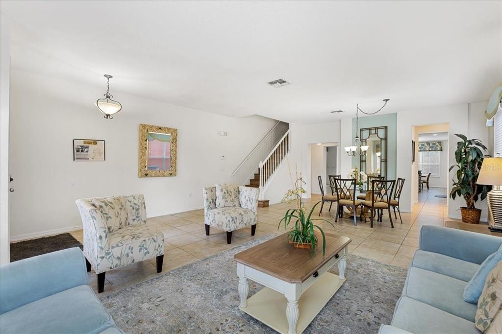 A living room with tile floors, a staircase, and a dining area in the background — 211 LAS FUENTES DRIVE, KISSIMMEE, FL
