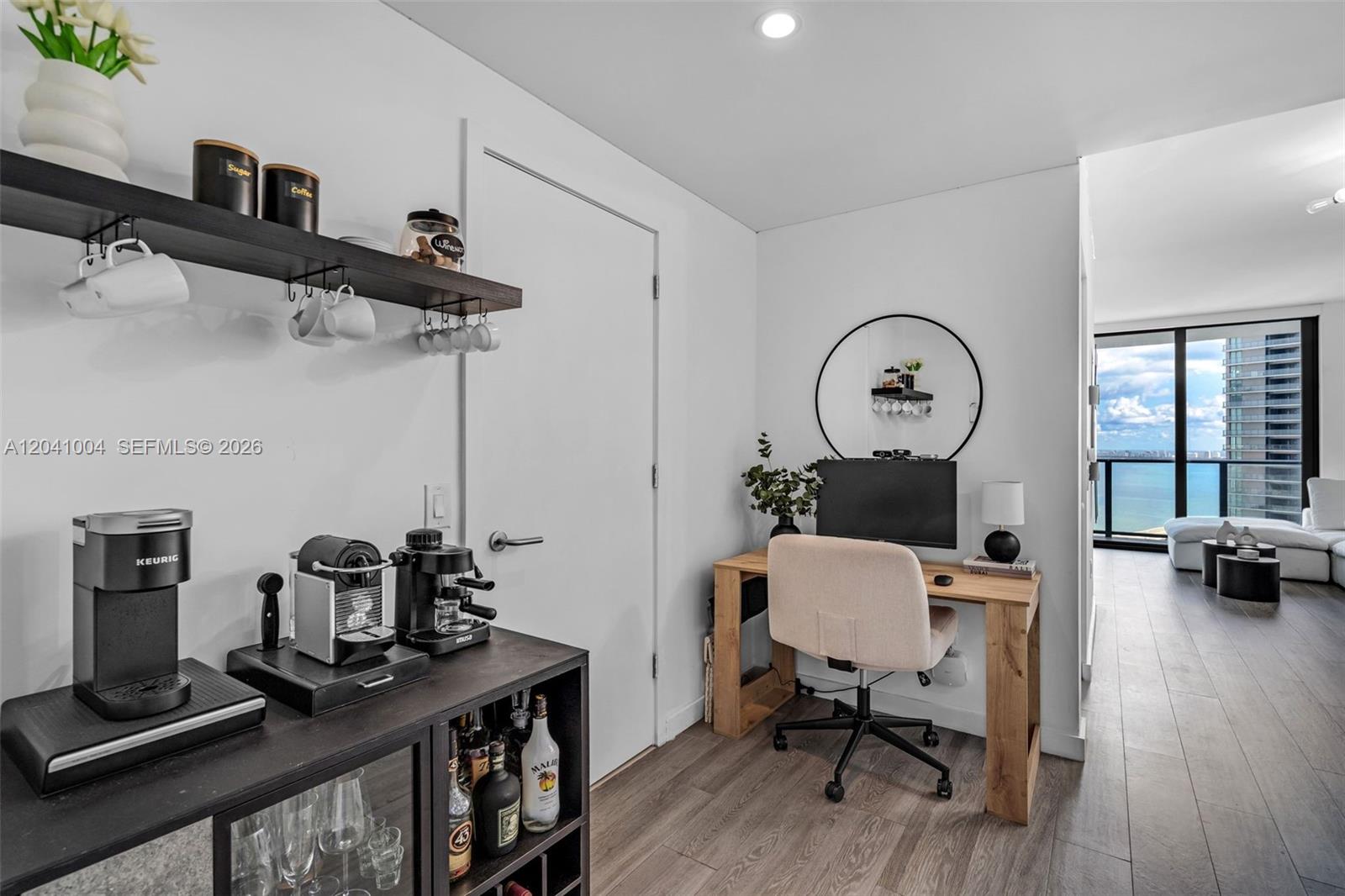 A room features a coffee station, a wooden desk with a computer, and a balcony view — 501 NE 31st St # 3704, Miami FL 33137, MIAMI, FL