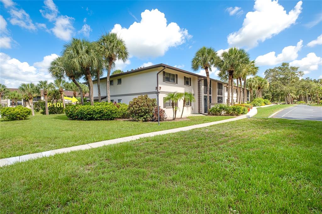 A sign for Oak Forrest Condominiums stands behind a bush with red flowers — 1515 FORREST NELSON BOULEVARD UNIT P101, PORT CHARLOTTE, FL