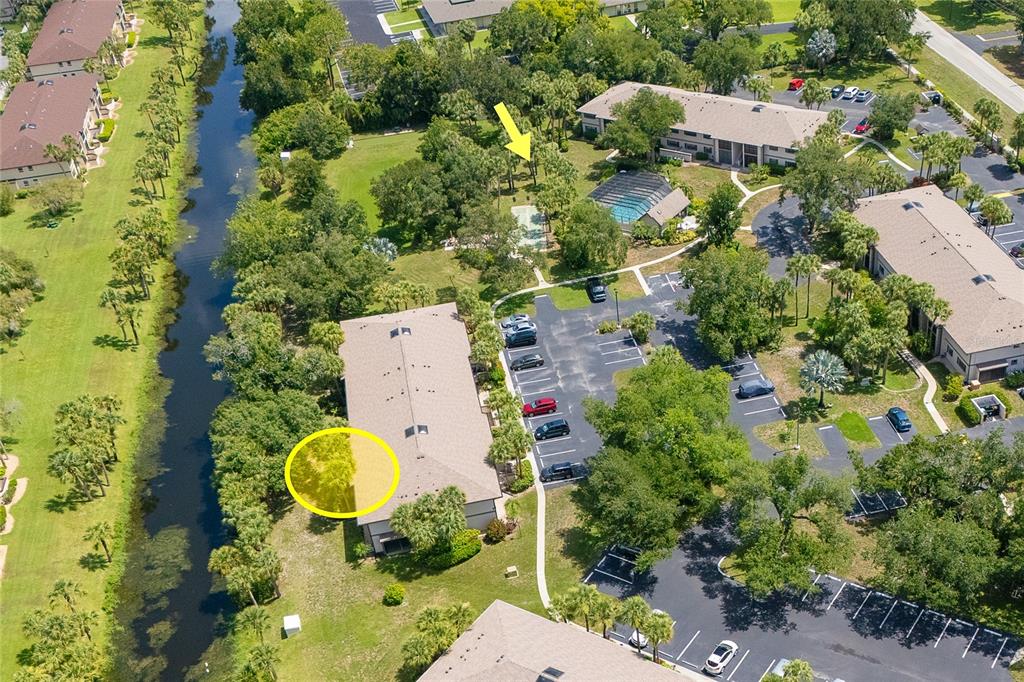 An aerial view shows a multi-story apartment building with a parking lot and canal — 1515 FORREST NELSON BOULEVARD UNIT P101, PORT CHARLOTTE, FL
