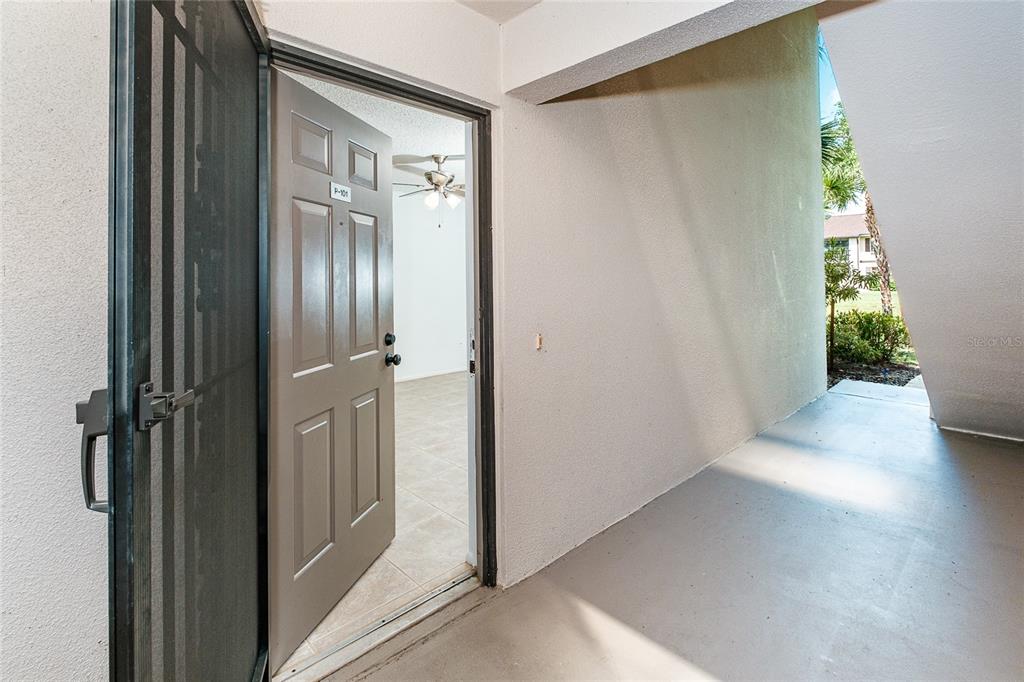 An open door reveals a tiled interior room with a ceiling fan from a porch — 1515 FORREST NELSON BOULEVARD UNIT P101, PORT CHARLOTTE, FL