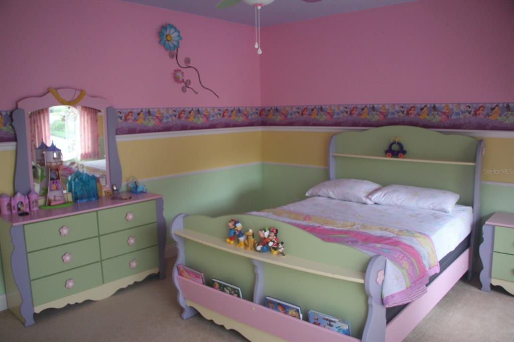 A child's bedroom features a green and purple bed, matching dresser, and colorful wall decor — 6935 BRESCIA WAY, ORLANDO, FL