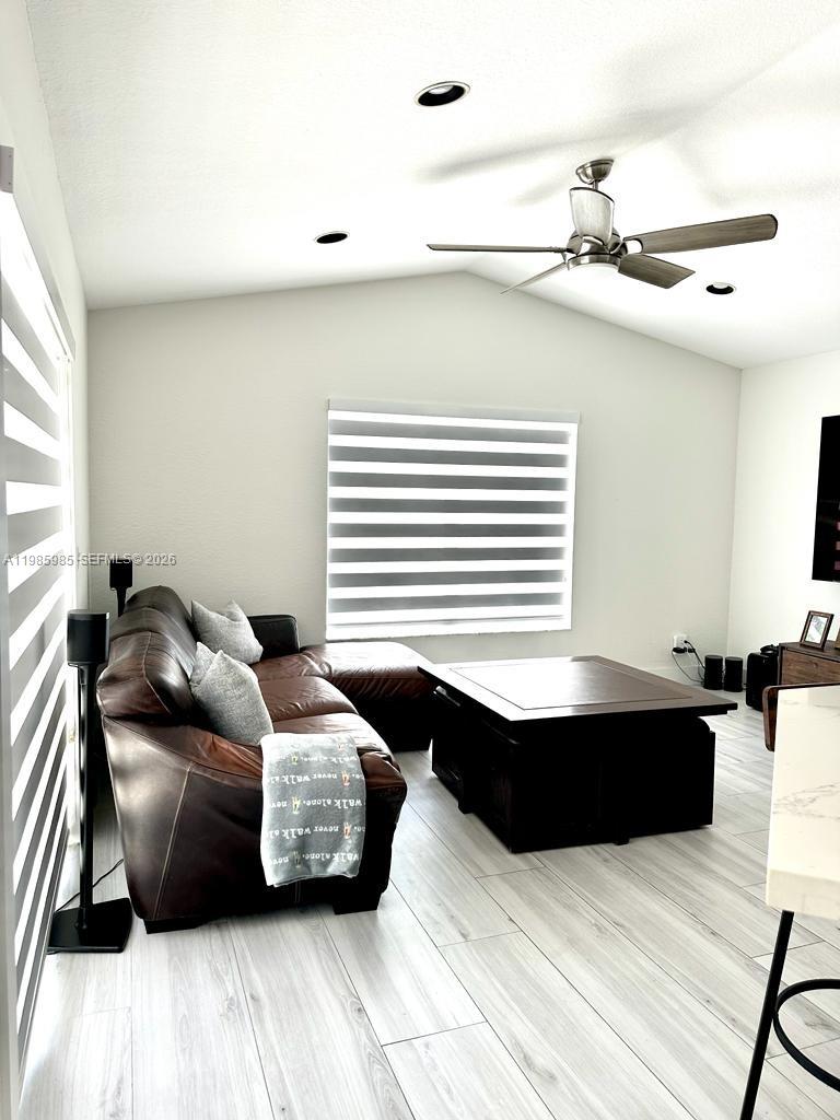 A living room features a brown leather sectional, a large coffee table, and light flooring — 2484 SW 177th Ter, Miramar FL 33029, MIRAMAR, FL