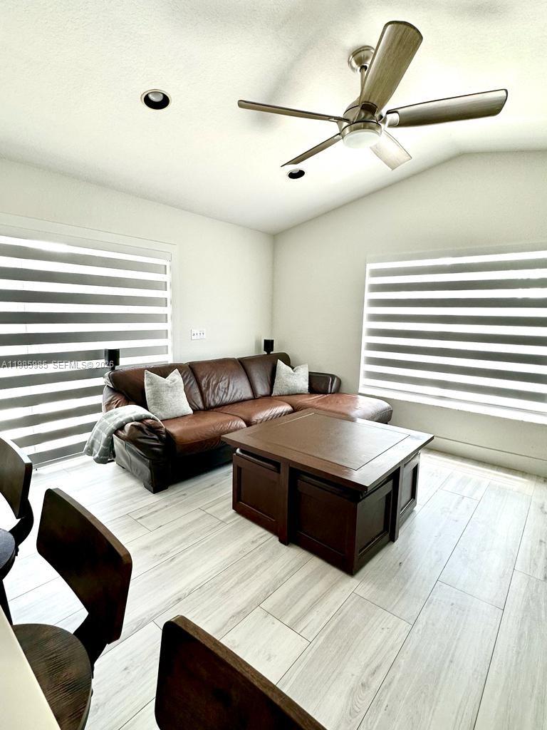A living room features a brown leather sectional, a wooden coffee table, and a ceiling fan — 2484 SW 177th Ter, Miramar FL 33029, MIRAMAR, FL