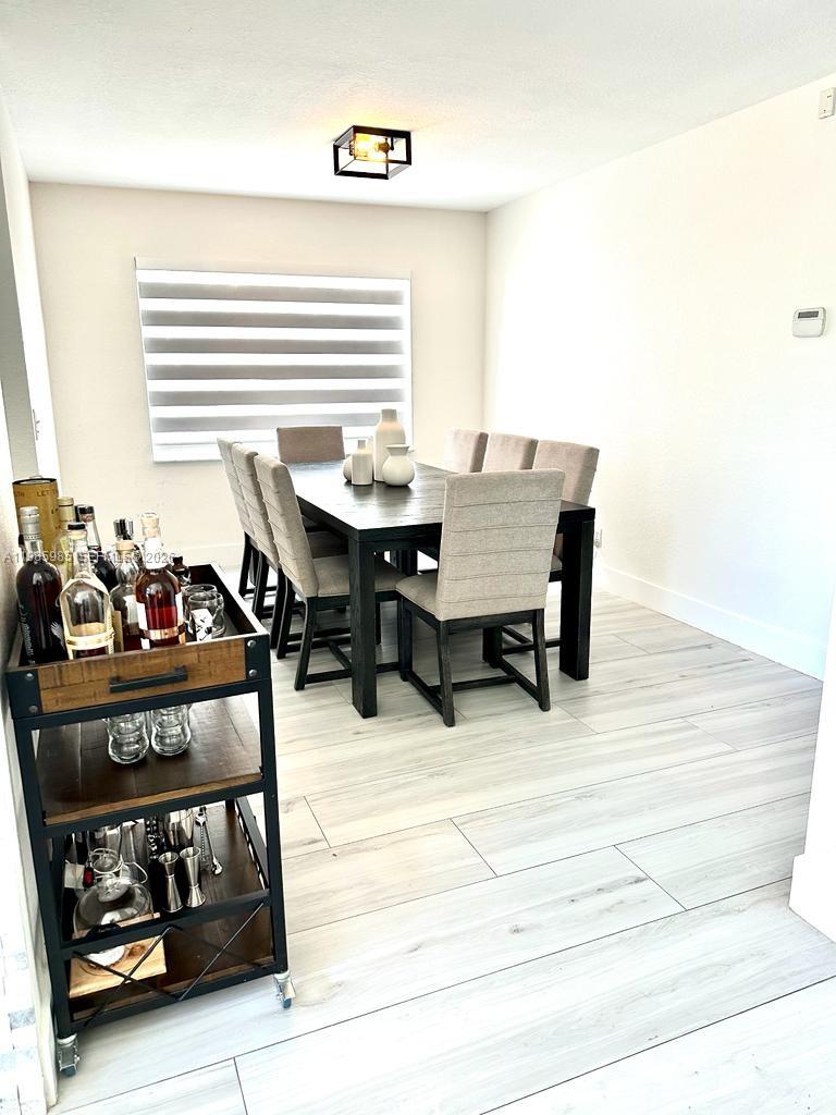 A dining room features a dark wood table, upholstered chairs, and a rolling bar cart — 2484 SW 177th Ter, Miramar FL 33029, MIRAMAR, FL