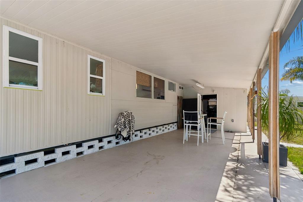 A covered patio with a concrete floor, white siding, and a decorative block wall base — 1915 SEMINOLE BOULEVARD UNIT 140, LARGO, FL