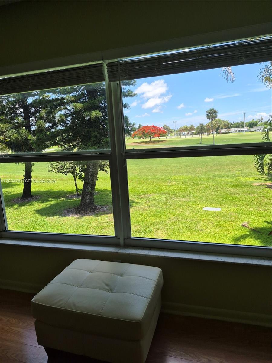 A white ottoman sits in a room facing a window with a golf course view — 7797 Golf Cir Dr # 206, Margate FL 33063, MARGATE, FL