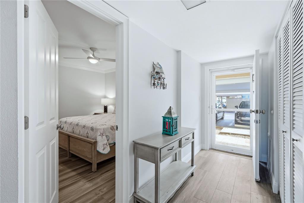 An entryway with a console table leads to a bedroom and an exterior parking area — 1150 TARPON CENTER DRIVE UNIT 1G, VENICE, FL
