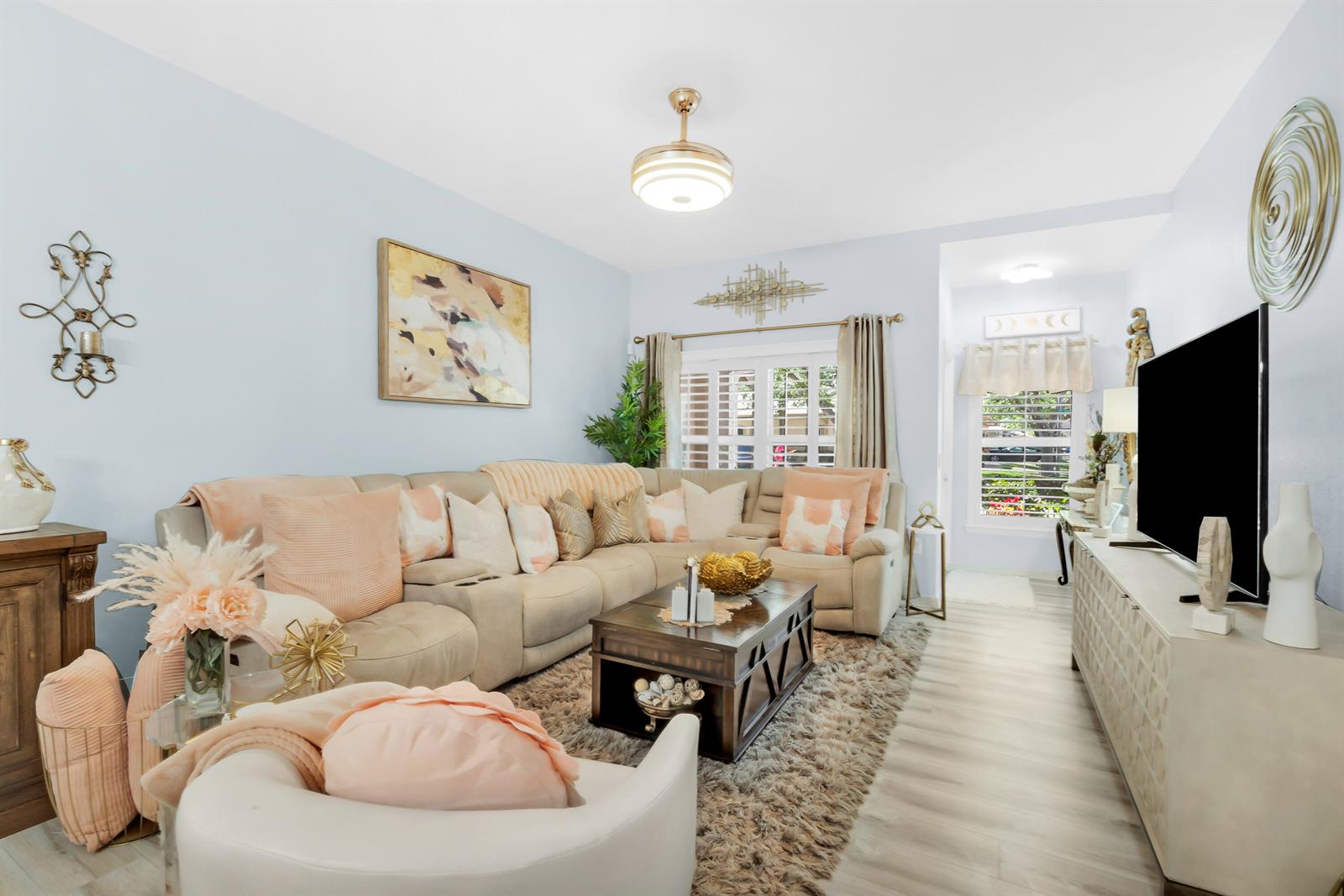 A living room features a beige sectional sofa, a coffee table, and a television console — 1868 E Sanderling Lane, Fort Pierce FL 34982, FORT PIERCE, FL