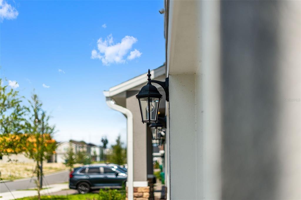 A black outdoor wall lantern is mounted on the side of a modern house — 1359 WOODLINE DRIVE, DELAND, FL