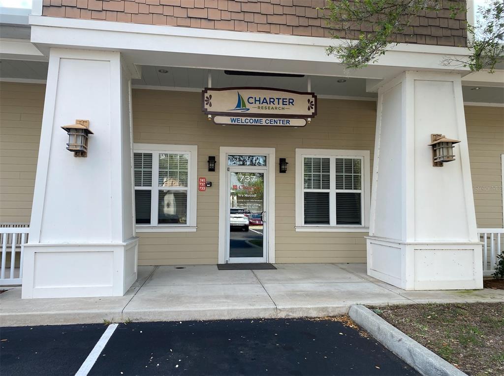 The exterior of a commercial building features a Charter Research welcome center sign above the door — 737 COUNTY ROAD 466, LADY LAKE, FL