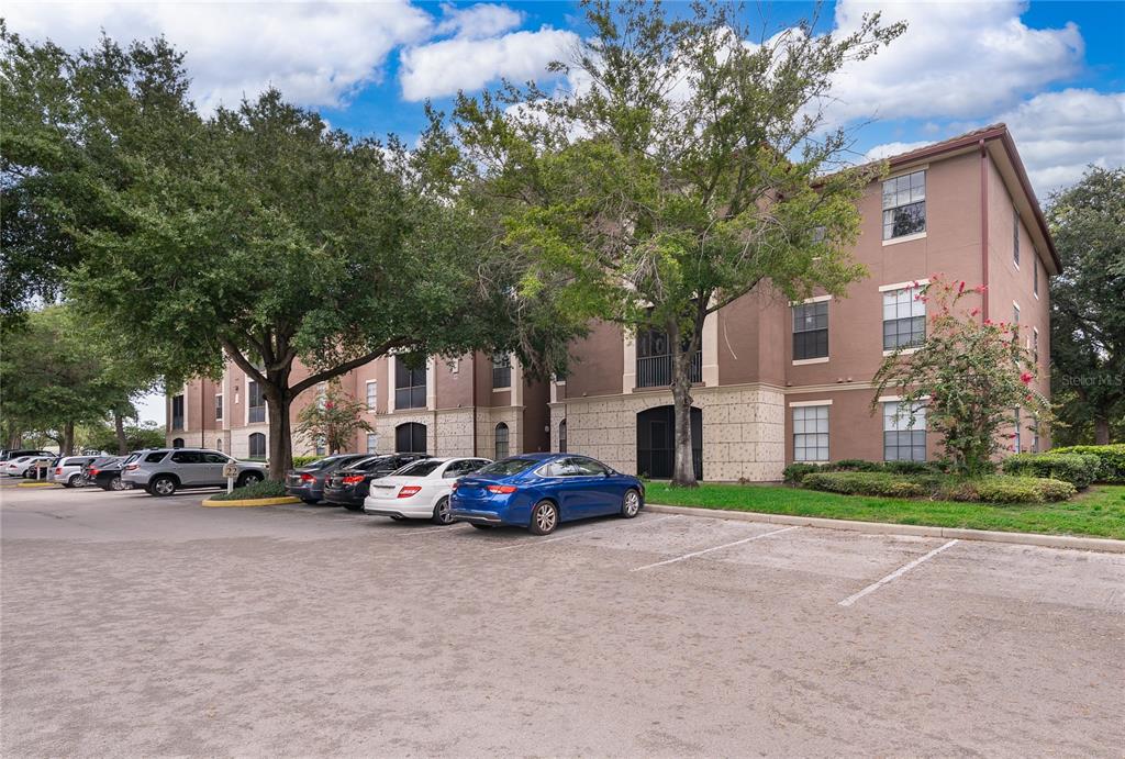 A three-story apartment building with a parking lot in the foreground — 6141 METROWEST BOULEVARD UNIT 305, ORLANDO, FL