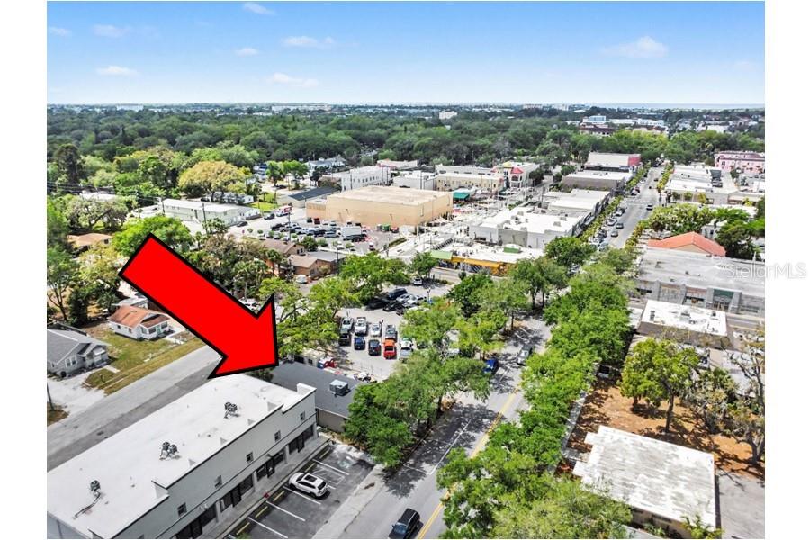 An aerial view shows a commercial building with a flat roof and adjacent parking lot — 5838 MAIN STREET, NEW PORT RICHEY, FL
