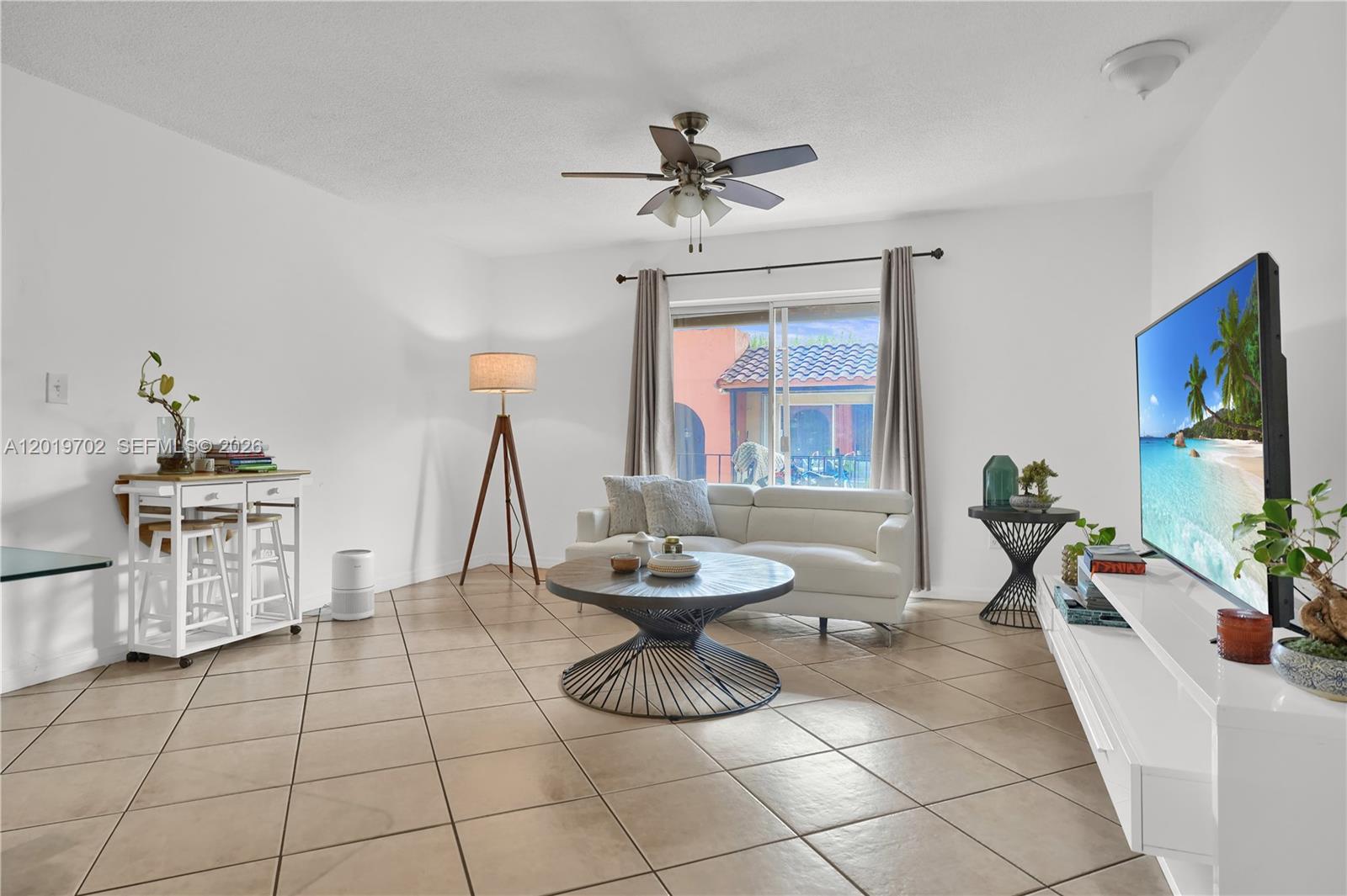 A living room features white walls, tile flooring, a white sofa, and a ceiling fan — 10786 N Kendall Dr # D18, Miami FL 33176, MIAMI, FL