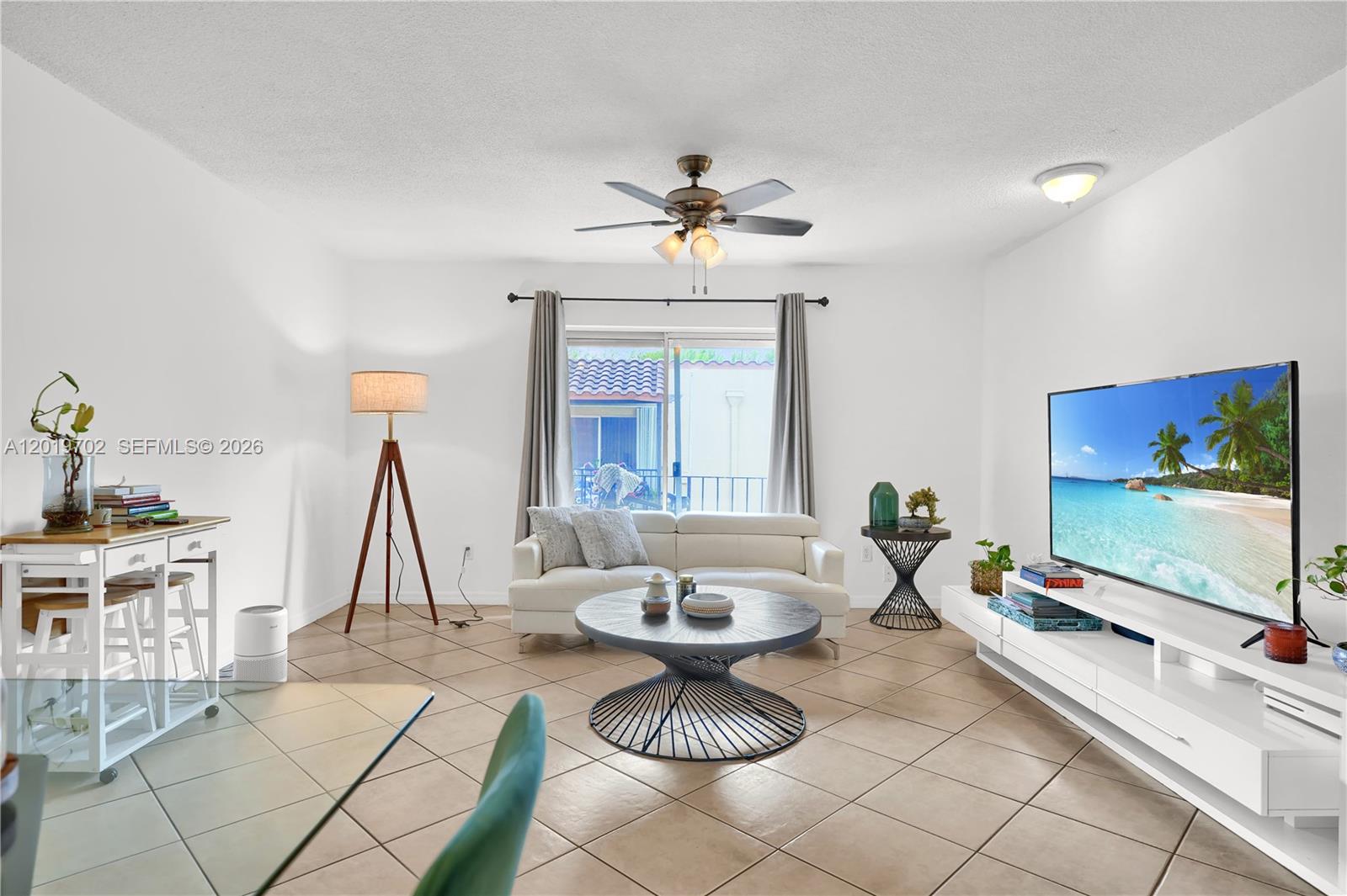 A living room features a white sofa, a circular coffee table, and a television console — 10786 N Kendall Dr # D18, Miami FL 33176, MIAMI, FL