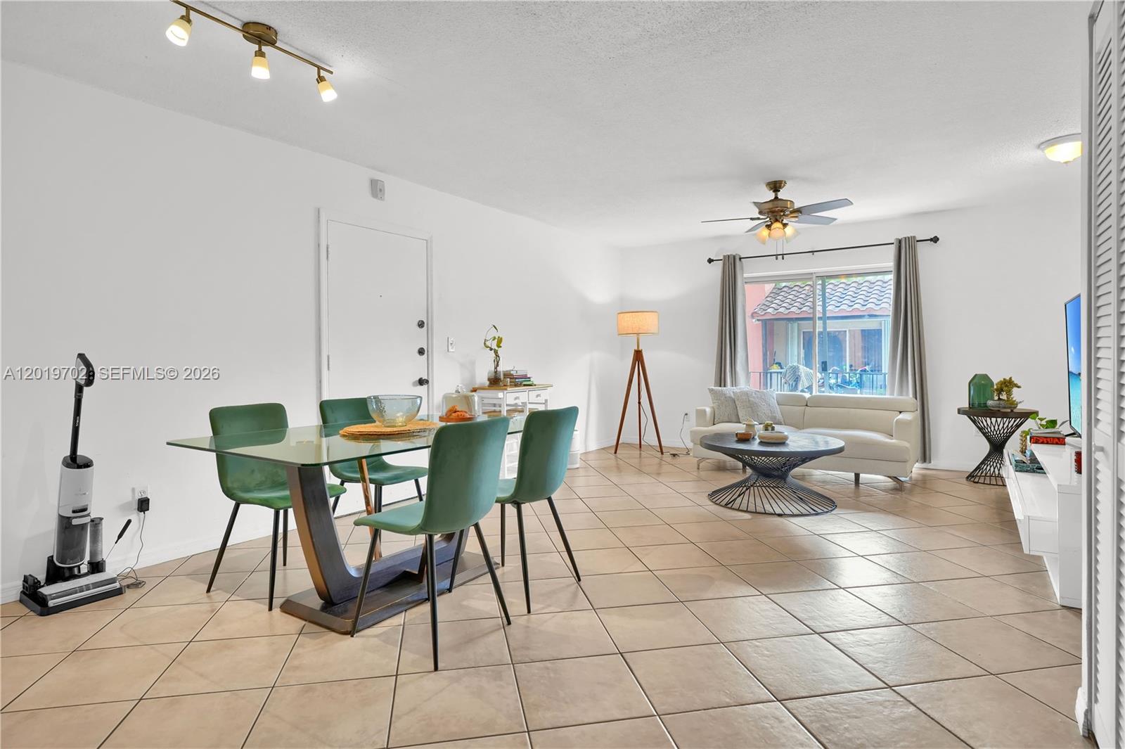 A living and dining area features tile flooring, green chairs, and a glass-topped table — 10786 N Kendall Dr # D18, Miami FL 33176, MIAMI, FL