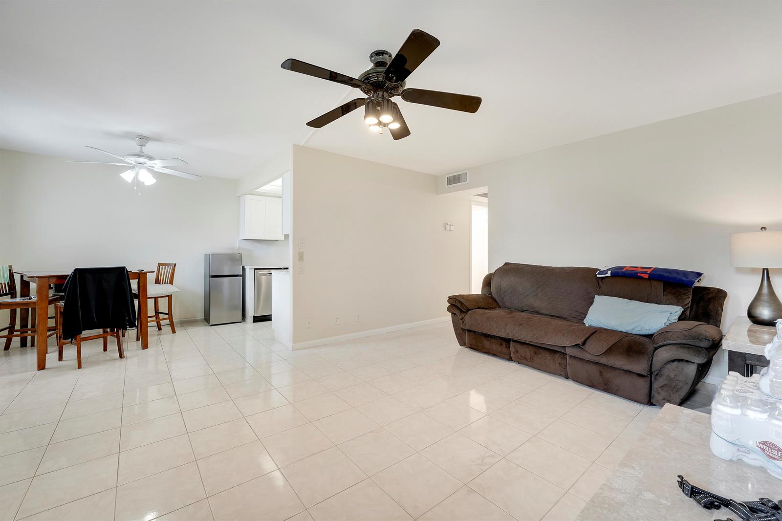 A living room and dining area with tile flooring, ceiling fans, and a brown sofa — 1011 Exeter, Boca Raton FL 33434, BOCA RATON, FL