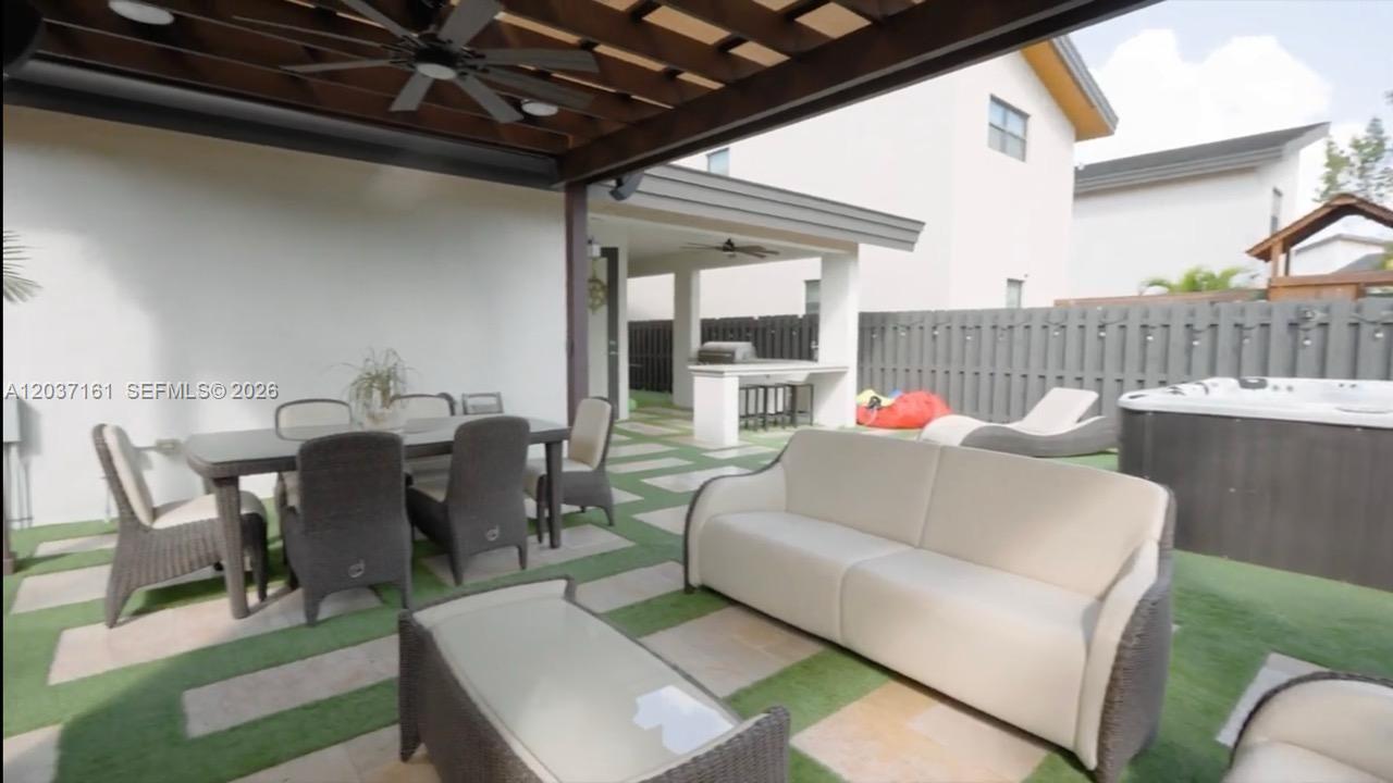 A covered patio features outdoor furniture, a dining set, a hot tub, and artificial turf — 7661 NW 103rd Ct, Doral FL 33178, DORAL, FL