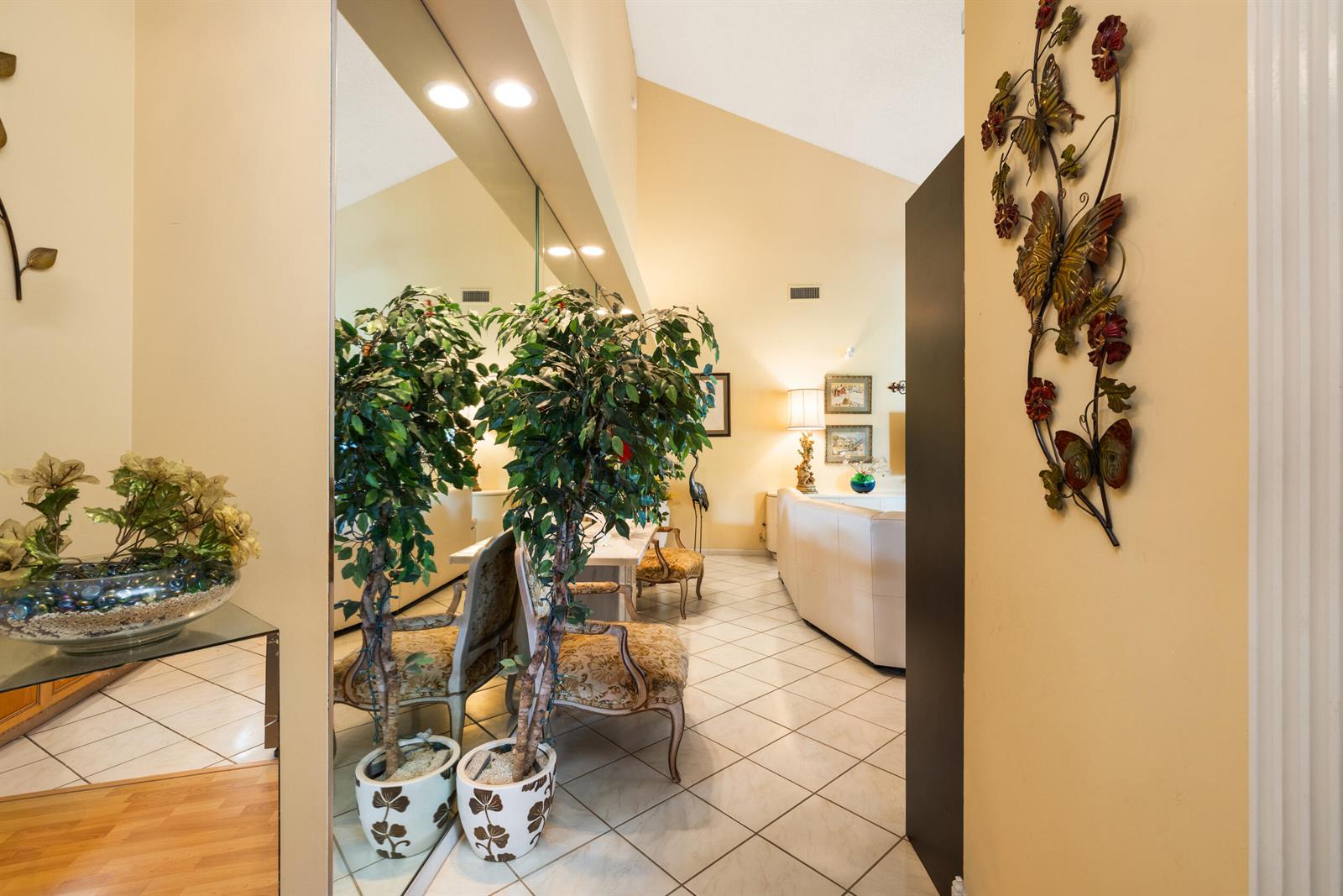 A tiled entryway leads into a living area with vaulted ceilings and a large wall mirror — 224 Cape Pointe Circle, Jupiter FL 33477, JUPITER, FL