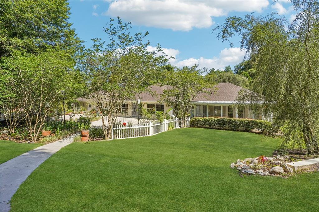 A single-story house with a white picket fence and a large green lawn — 4546 GRIFFIN VIEW DRIVE, LADY LAKE, FL