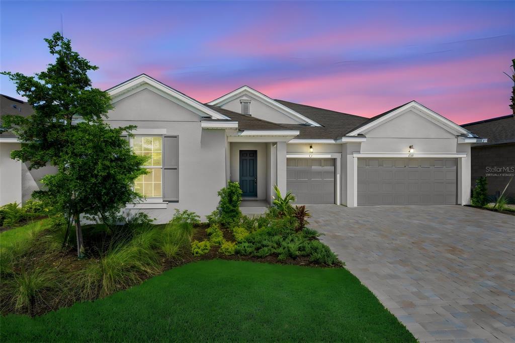 A single-story house with a gray exterior, a paved driveway, and a three-car garage — 17013 GREAT HERON LANE, PUNTA GORDA, FL