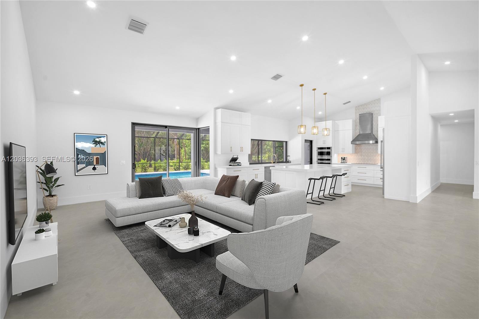 A modern open-concept living room and kitchen feature white cabinetry, tile flooring, and a pool — 16100 SW 252nd St, Homestead FL 33031, HOMESTEAD, FL