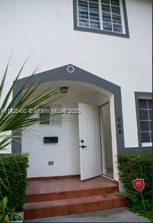 The exterior entrance of a white building features a dark gray arched doorway and steps — 968 N 18th Ct, Hollywood FL 33020, HOLLYWOOD, FL