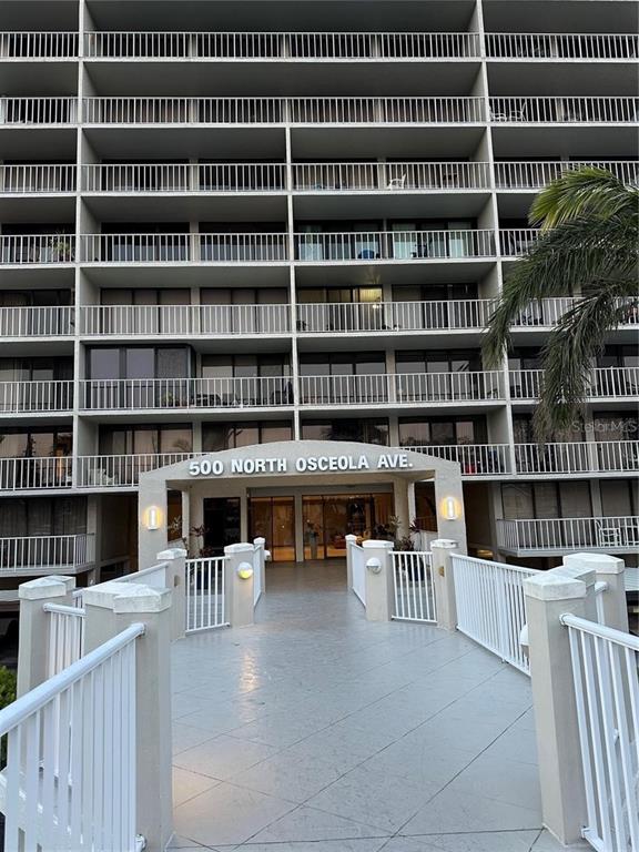 A multi-story apartment building features a pedestrian walkway leading to the main entrance — 500 N OSCEOLA AVENUE UNIT 403, CLEARWATER, FL