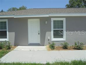 A gray exterior wall features a white front door and a single window — 1 FISHER TERRACE TRACE UNIT 201, OCKLAWAHA, FL