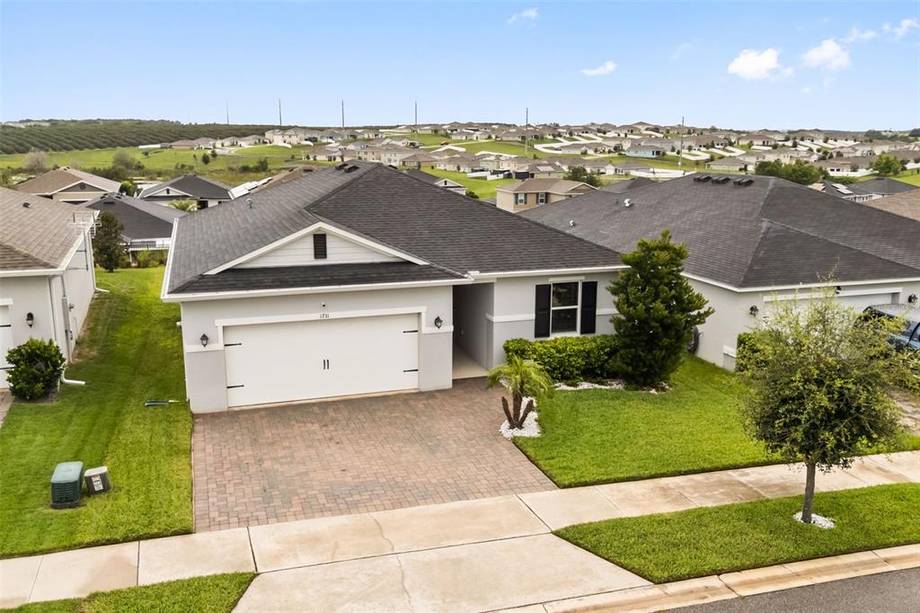 An aerial view of a single-story suburban house with a paved driveway and shingled roof — 1731 WILSON PRAIRIE CIRCLE, GROVELAND, FL