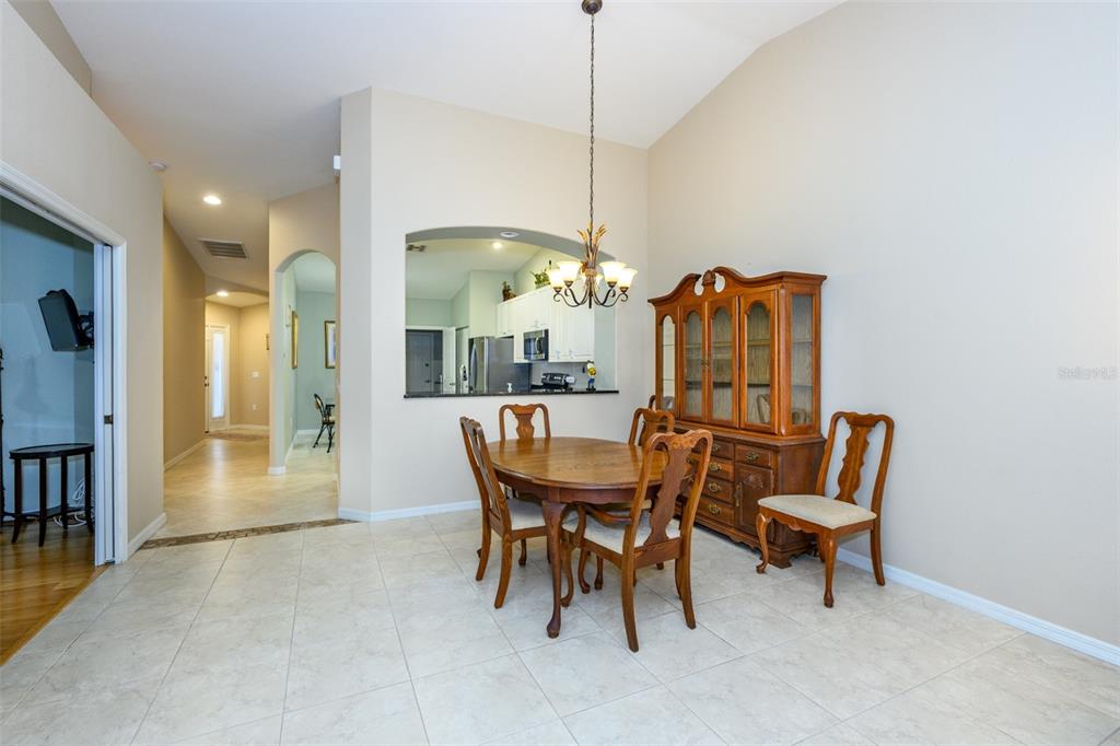 A dining area features a wooden table and hutch, tile flooring, and a kitchen pass-through — 327 MONACO DRIVE UNIT 12, PUNTA GORDA, FL