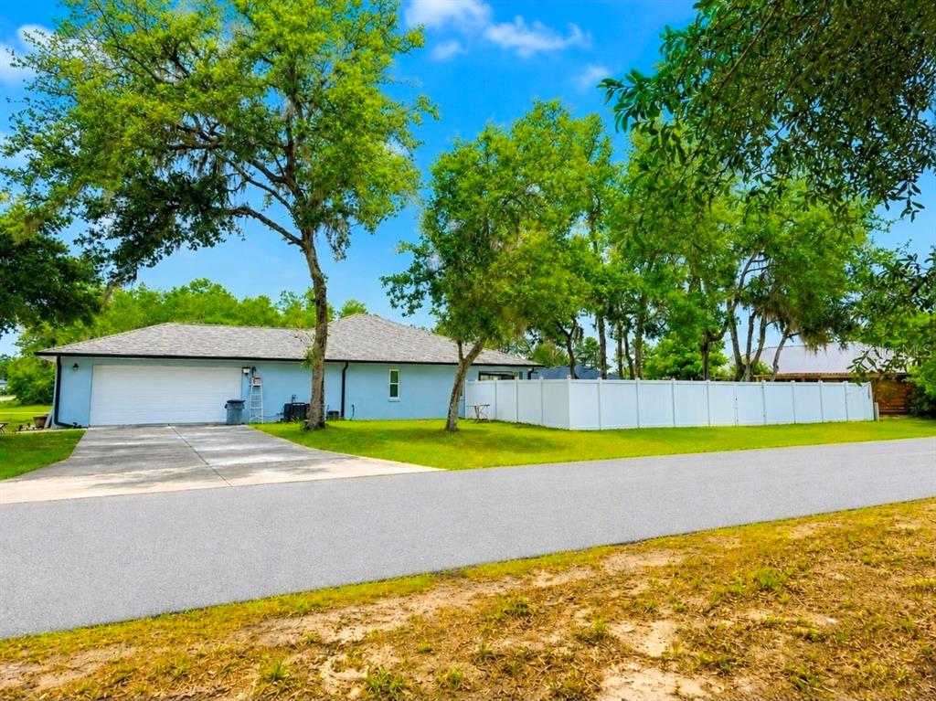 A light blue house with a two-car garage and a white vinyl privacy fence — 3805 SW 115TH STREET, OCALA, FL
