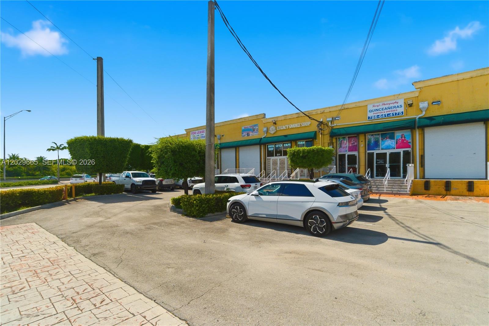 A yellow commercial strip mall building features a smoke shop and a photography studio — 1815 W okeechobee rd, Hialeah FL 33010, HIALEAH, FL