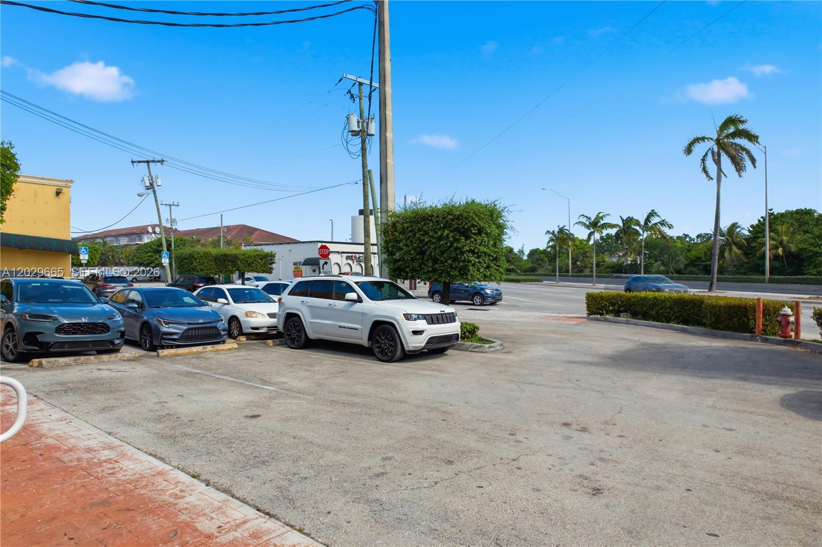 A parking lot with several parked cars sits in front of a commercial building — 1815 W okeechobee rd, Hialeah FL 33010, HIALEAH, FL