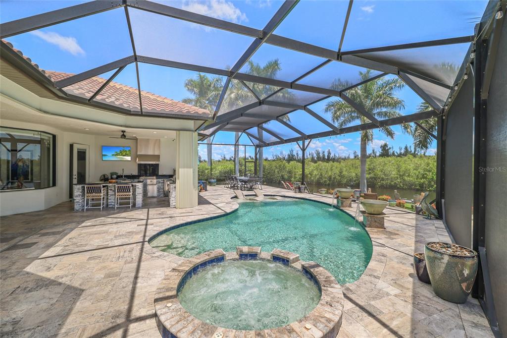 An open-concept living room and kitchen feature coffered ceilings, tile flooring, and wooden cabinetry — 1355 GREBE DRIVE, PUNTA GORDA, FL