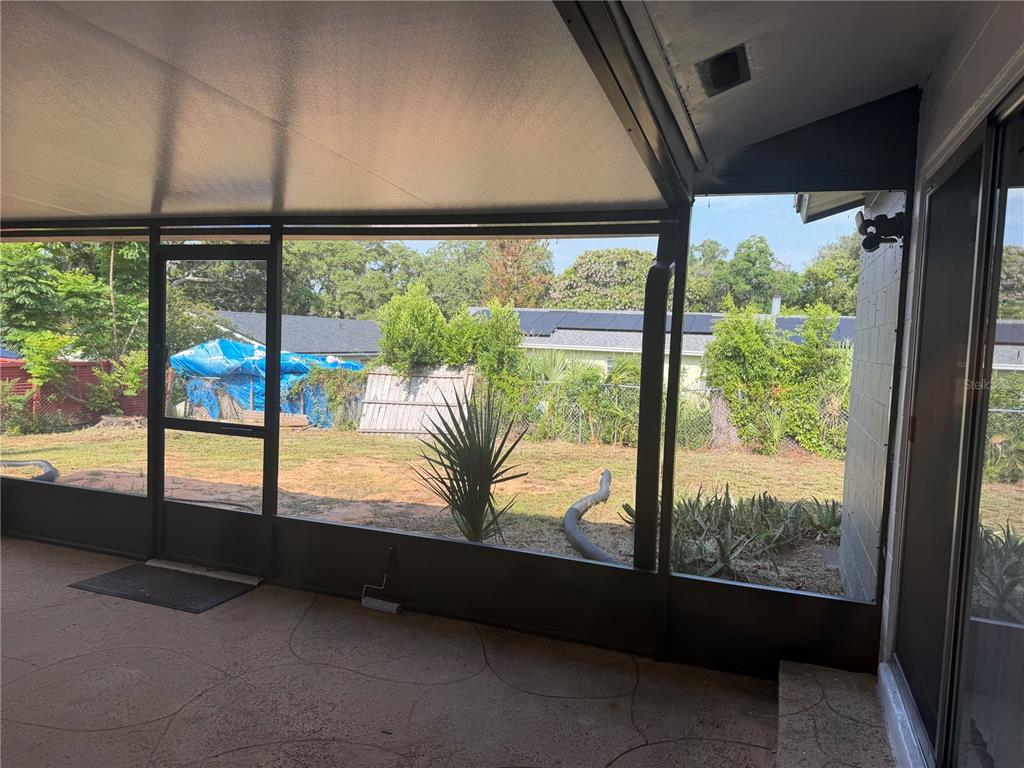 An empty room features light gray walls, dark wood-look flooring, and a large window with blinds — 2262 MENOMONEE COURT, ORLANDO, FL