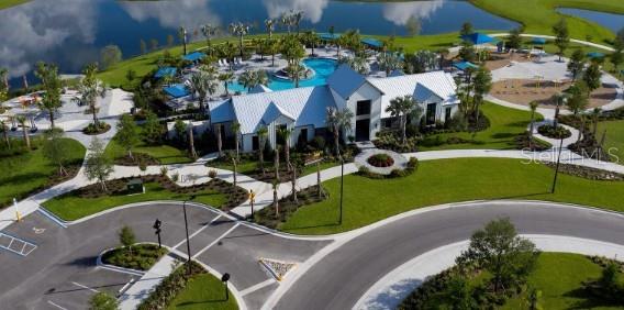 An aerial view of a community clubhouse with a swimming pool, playground, and parking lot — 10732 OAK BEND DRIVE, PARRISH, FL