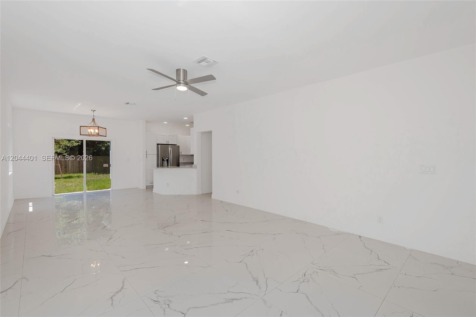 A bright, open-concept living area features white walls, marble-patterned tile floors, and a ceiling fan — 731 SW 6th St, Dania Beach FL 33004, DANIA BEACH, FL