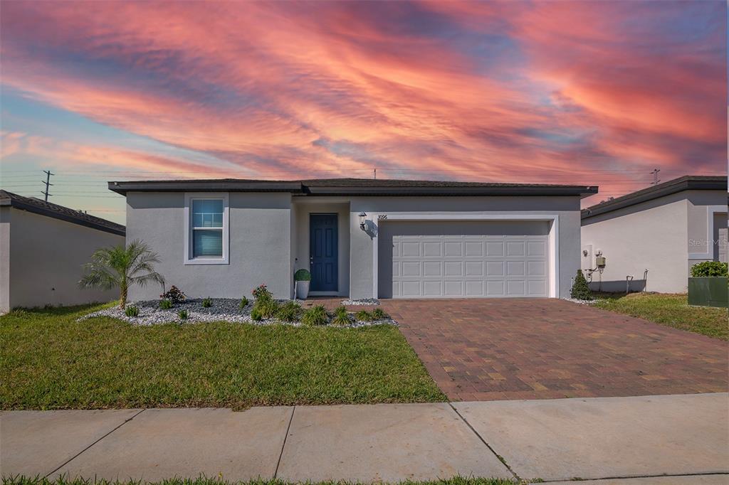 A single-story house with a gray exterior, a two-car garage, and a paved driveway — 3096 CASSIDY LANE, HAINES CITY, FL
