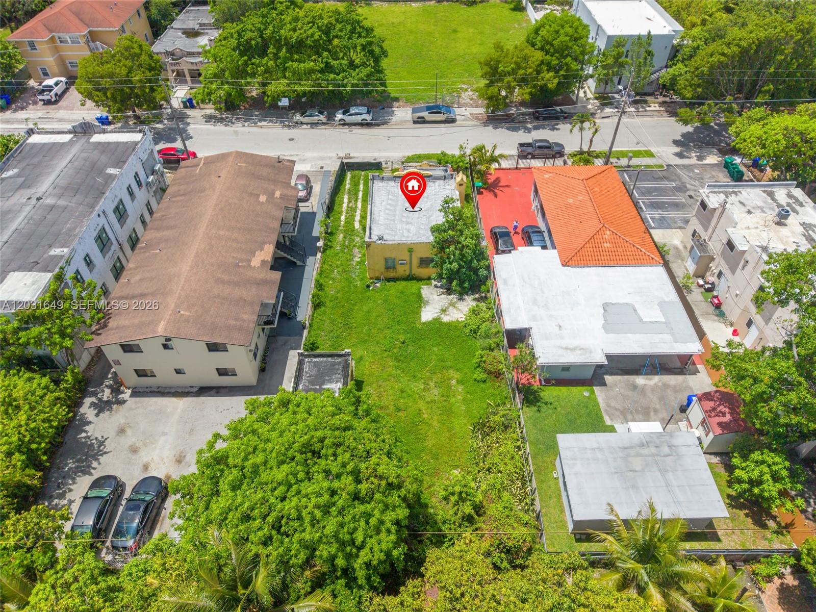 An aerial view shows a yellow building with a red location pin on its roof — 559 NW 34th St, Miami FL 33127, MIAMI, FL