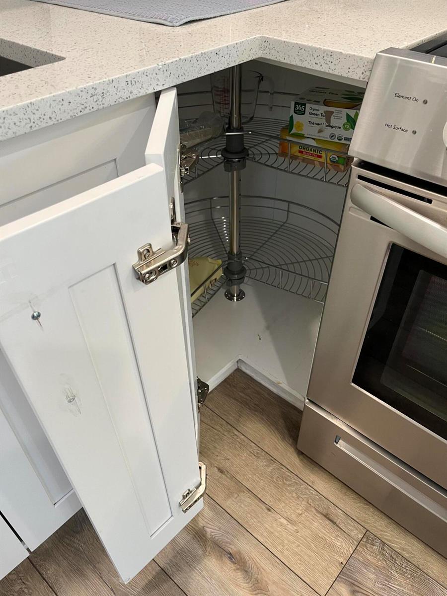 A kitchen corner cabinet features a white door and a rotating wire lazy Susan shelf — 812 Burgundy Q, Delray Beach FL 33484, DELRAY BEACH, FL